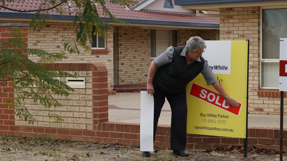 SOLD: Kay Newbigging puts on a sold sticker after a successful property sale on Monday. There are still plenty of reasons to be confident in the local property market. 