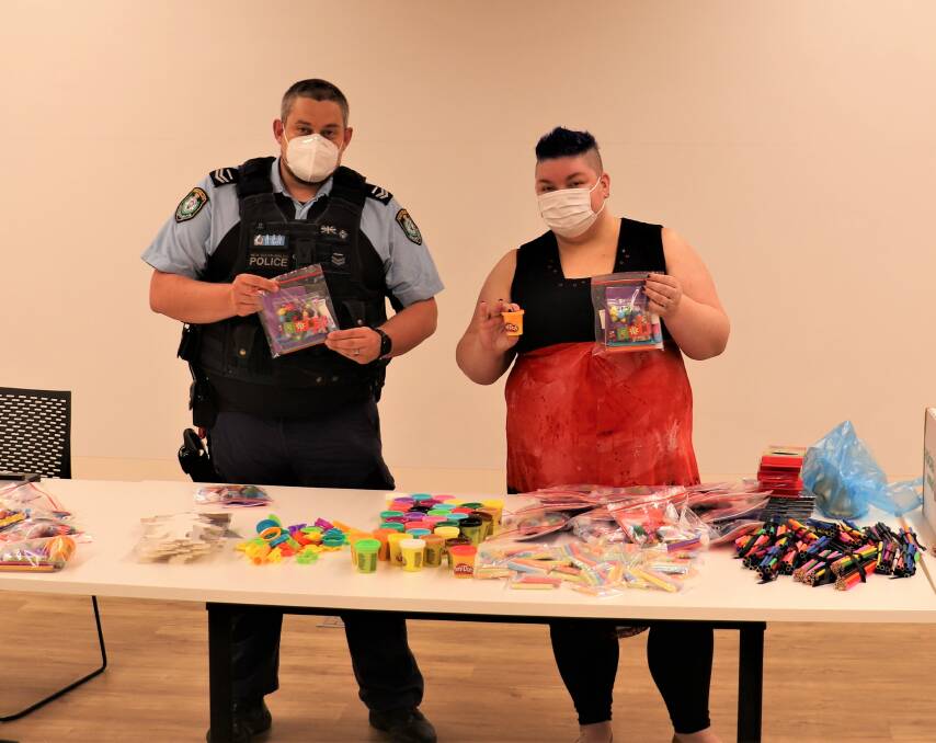 LIVING IN LOCKDOWN: Parkes Constable Chris Evans from the Central West Police District and Roxanne Gallacher from the Parkes Shire Council with some of the 'Boredom Buster' packs that are available. Photo: SUPPLIED.