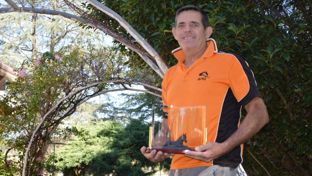 Tony Dumesny with an award from Harness Racing NSW.