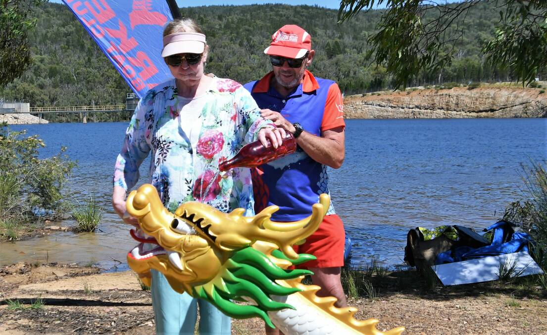 ALWAYS SUPPORTING OTHERS: Liz Matthews anoints the new dragon boat 'Lizzie', which is named in her honour. She's pictured here with Parkes Dragon Boat Club's Bill Thomas. Photo: Jenny Kingham.