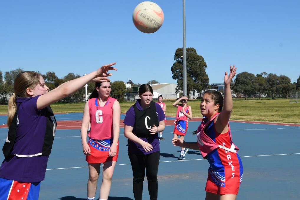 A scene from one of Parkes netball's Saturday games - Laura Burkitt attempts to pass the ball over Savannah Latu.
