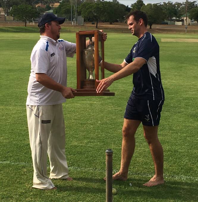 Parkes captain Anthony Heraghty handed the Grinsted Cup to Cowra cricket captain Nick Berry during a 2018 match.