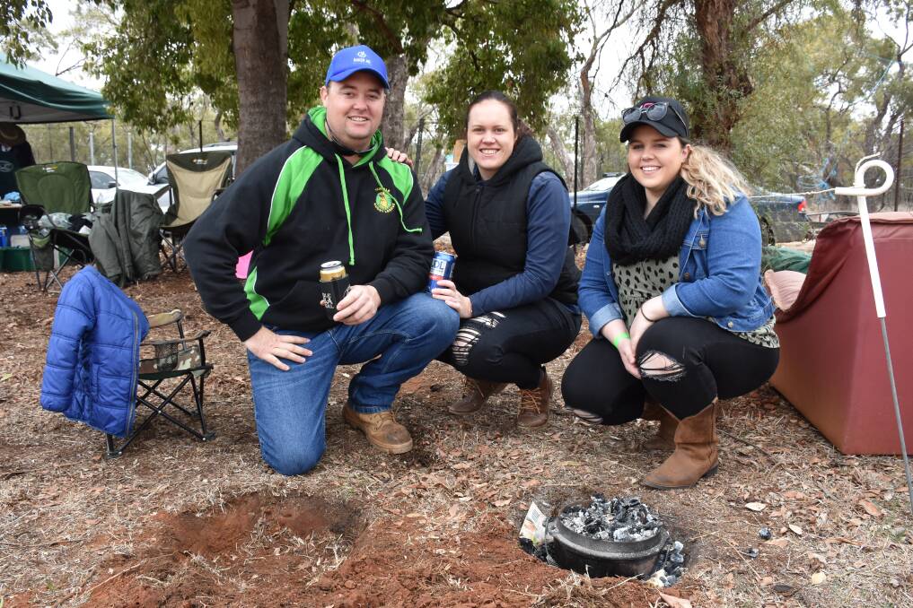 Down to earth: Trundle locals Michael and Tamilla Bolam and Stacey Edwards cook a leg of lamb in their camp oven. Photo: File.