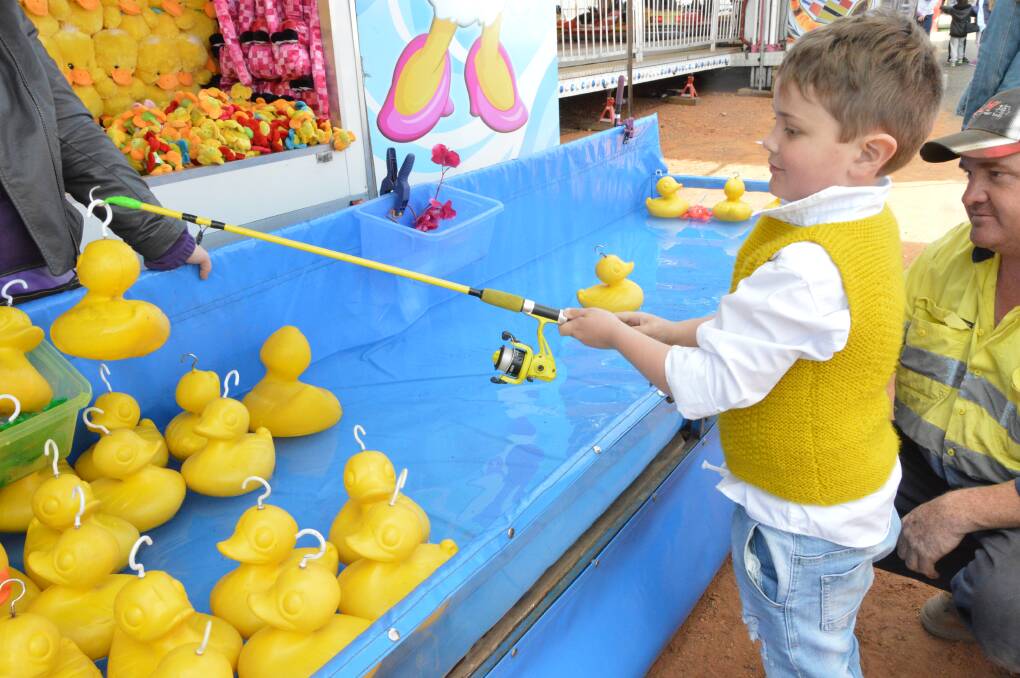 Fishing for prizes: Six-year-old George Miles went fishing for ducks and frogs with his eyes on a prize during a trip down sideshow alley. Photo: Christine Little.