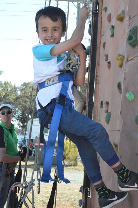 NEW HEIGHTS: Bailey Dart had fun challenging himself on the rock climbing attraction at the 2017 Peak Hill Show. The challenge will be back again this year. Photo: Christine Little.
