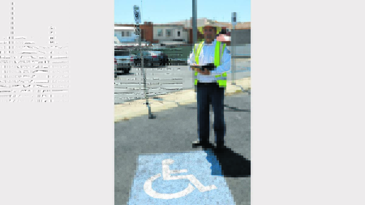 Parking officer, Greg Gordon shows the new parking signs now in place. 