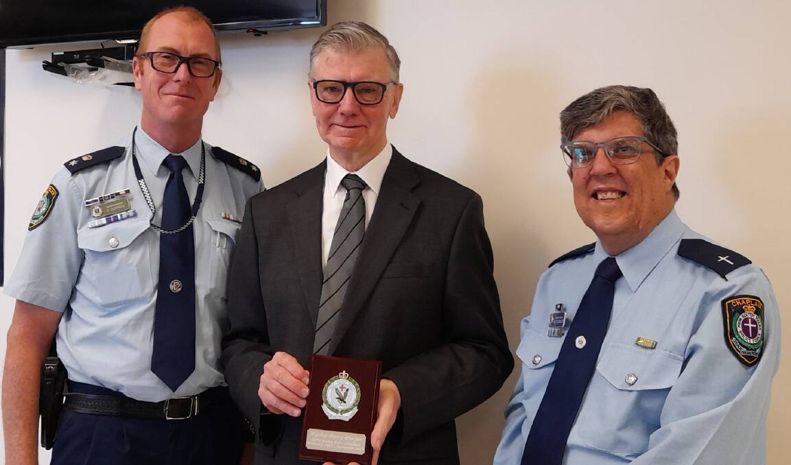 Central West Police District commander Superintendent Brendan Gorman and NSW Senior Police Chaplain Reverend Ian Schoonwater presented Father Barry Dwyer from Parkes with a plaque to thank him for his 40 years of service as police chaplain. Photo by Central West Police District