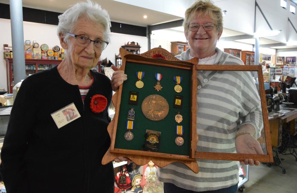 100 YEARS AGO: Henry Parkes Museum volunteers Lorice White - also a member of the Parkes RSL Women's Auxiliary - and Rose Jones with Private Jacob Sydney Hansen's Dead Man's Penny. Photo: Christine Little