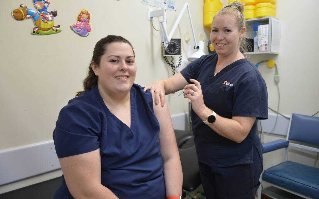 FRONTLINE WORKERS: Ochre practice nurse Hannah Davey (right) gave fellow nurse Michaela Ireland her first dose of the AstraZeneca vaccine last week. Photo: Christine Little