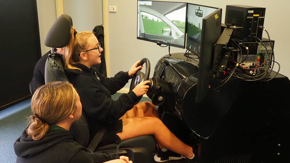 IN THE DRIVER'S SEAT: Parkes Christian School students test their skills and knowledge on the driving simulator. Photo: Ken Engsmyr