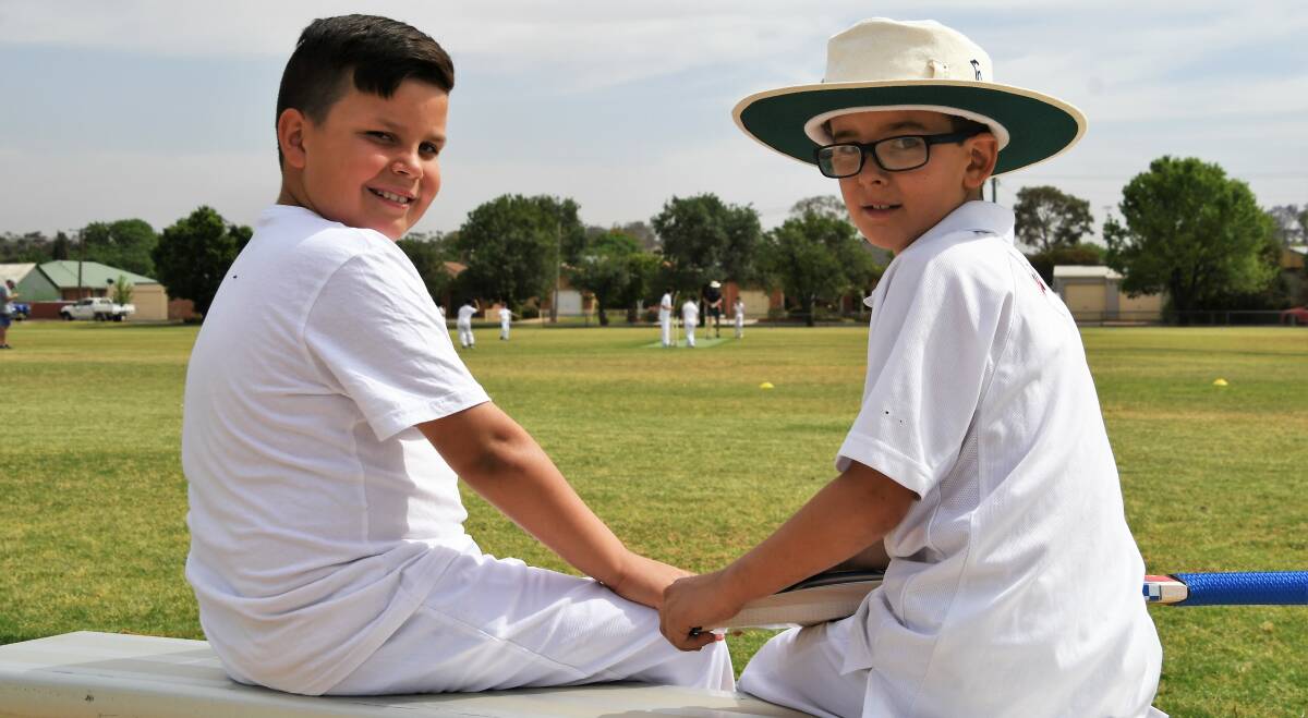 SAY CHEESE: Under 10 players Quentin Spice and Hughie Orr take a break from batting during a match. Photos: Jenny Kingham
