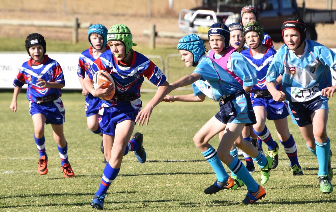 UNDER 10S: Parkes' under 10 player Oakley Fliedner takes charge with the ball during a home game against Red Bend Catholic College, with Jaylen Kelly and Ryan Whitney (both left) in support. Photo: Jenny Kingham