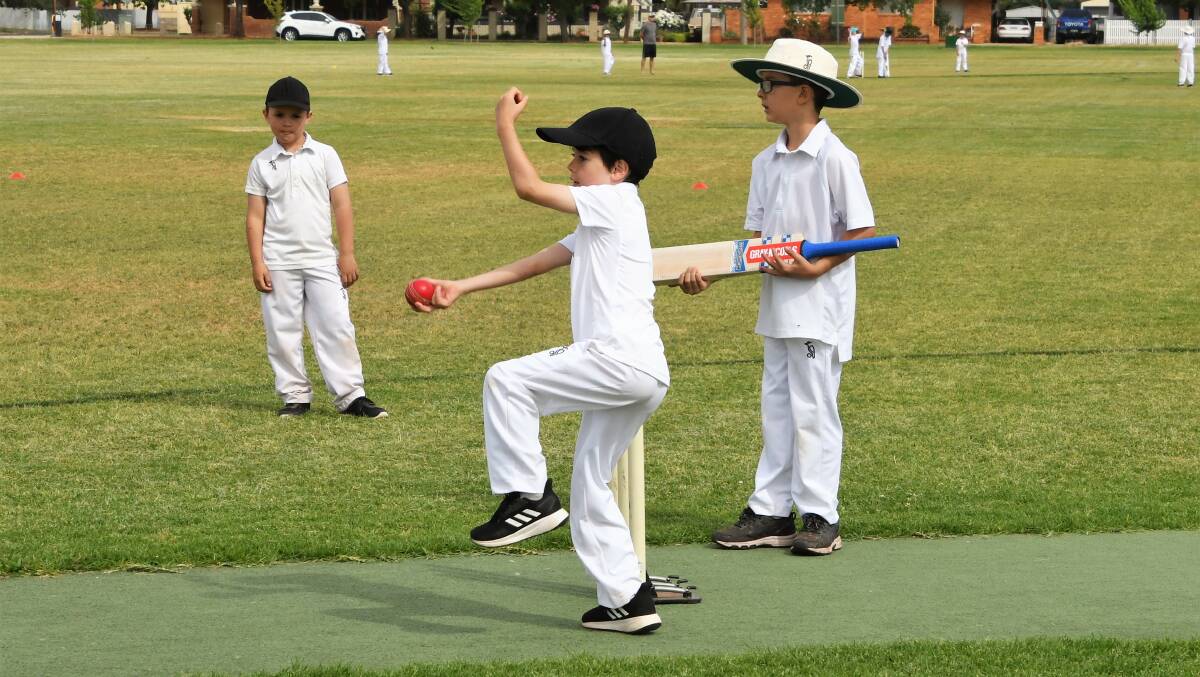 UNDER 10S: Eli Symington bowls for Parkes Crushers during a match at Keast Oval, while his fellow Under 10 competitors watch on. Photo: Jenny Kingham