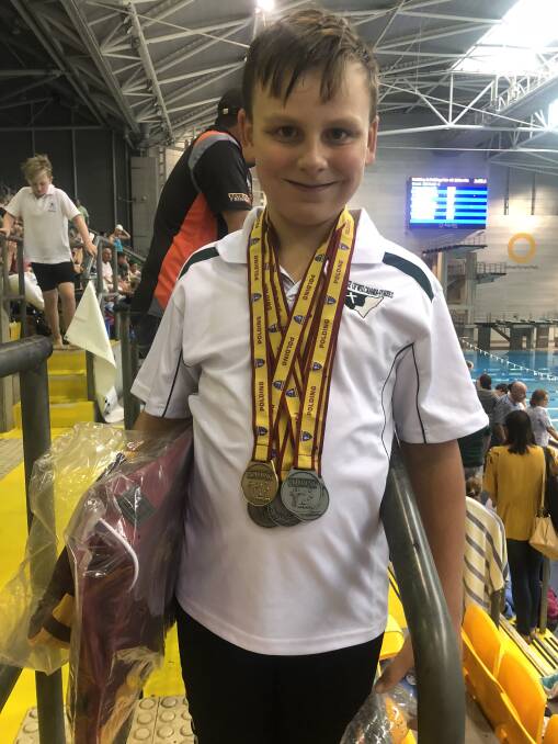 MEDAL HAUL: Matty Price proudly displaying his swag medals he collected at the NSW Catholic Primary School Sports Council Swimming Championships in Homebush. Photo: Submitted