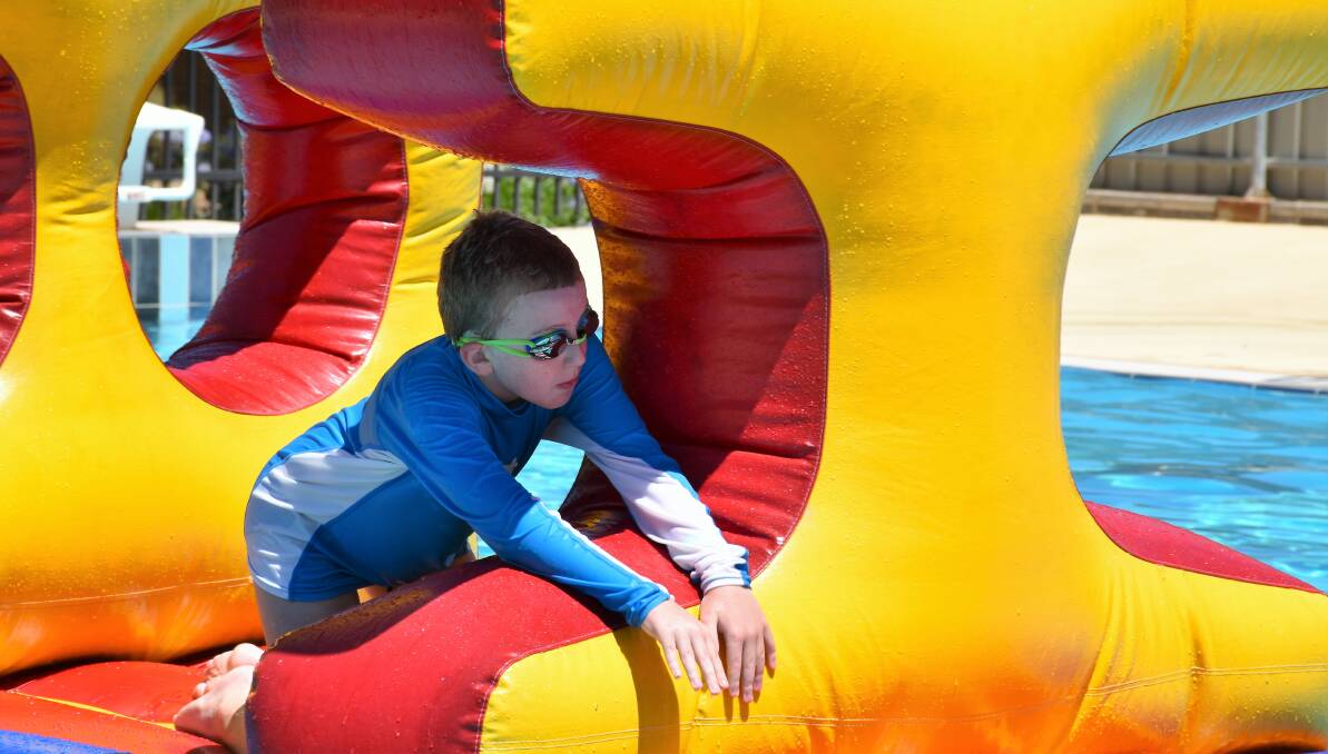 FUNDAY SUNDAY: Flynn Colley-Anderson took on the inflatable obstacle course during the new Family Funday Sunday event at the Parkes Pool. Photo: Jenny Kingham