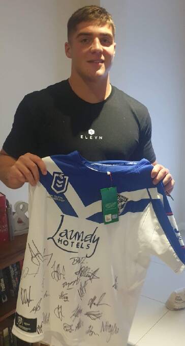 AUCTION: Canterbury-Bankstown Bulldogs first grade player Matt Doorey holding the signed jersey that was auctioned off over the weekend for the Community Christmas cause. Photo: Submitted
