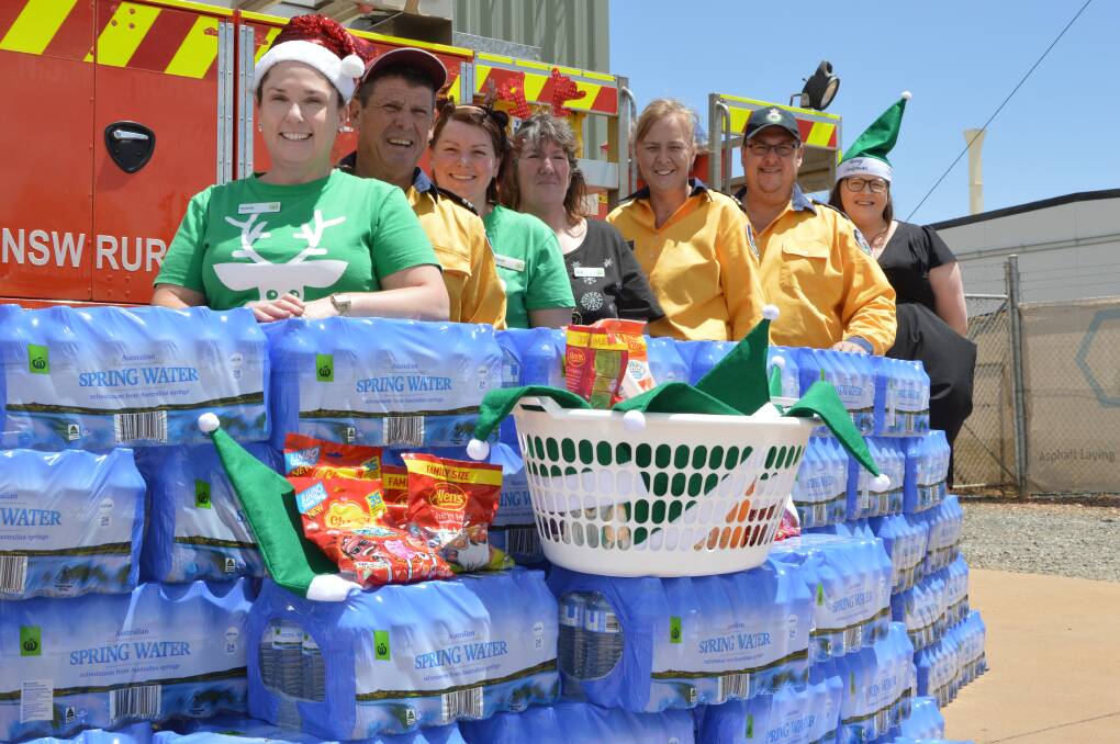 DELIVERY: Parkes Woolworths store manager Kerrie Kennedy, Parkes Headquarters Rural Fire Brigade senior deputy captain Steve Chester, Sarah Spradbrow, Gail Legg, Parkes Headquarters Rural Fire Brigade captain Vicki Williams, Michael Trueber and Brittany Barber welcome Friday's delivery. Photo: Christine Little