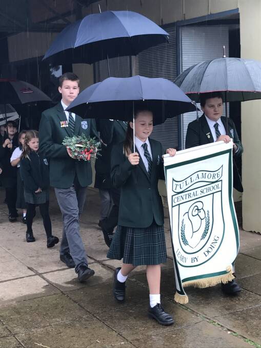 MARCH: Tullamore Central School vice captain Lachlan Curr (back) and primary captains Lisa Edwards and Jeffrey McLean lead their peers in the Anzac Day march.