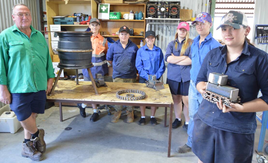 PROGRAM A SUCCESS: John Grady with his eager students at Trundle Central School and some of their work, a fire bucket and model dozers, from left, Jordan Whalan, Sam Charlton, Miranda Barnes, Laney Cantrell, Max Longhurst and Kiera Stevson. Photo: Christine Little
