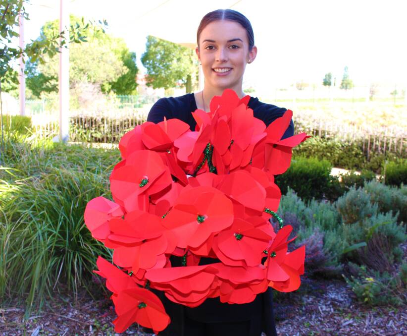 Parkes Shire Council's tourism trainee, Claire Bignell with the handmade paper poppies that will go on display at the Parkes Visitor Information Centre.
