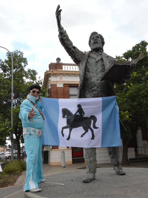 CHALLENGE ACCEPTED: Parkes Mayor Ken Keith OAM was happy to hop into his famous blue Elvis jumpsuit for a photo with the Coventry flag on our Henry Parkes Statue. Photo: Christine Little