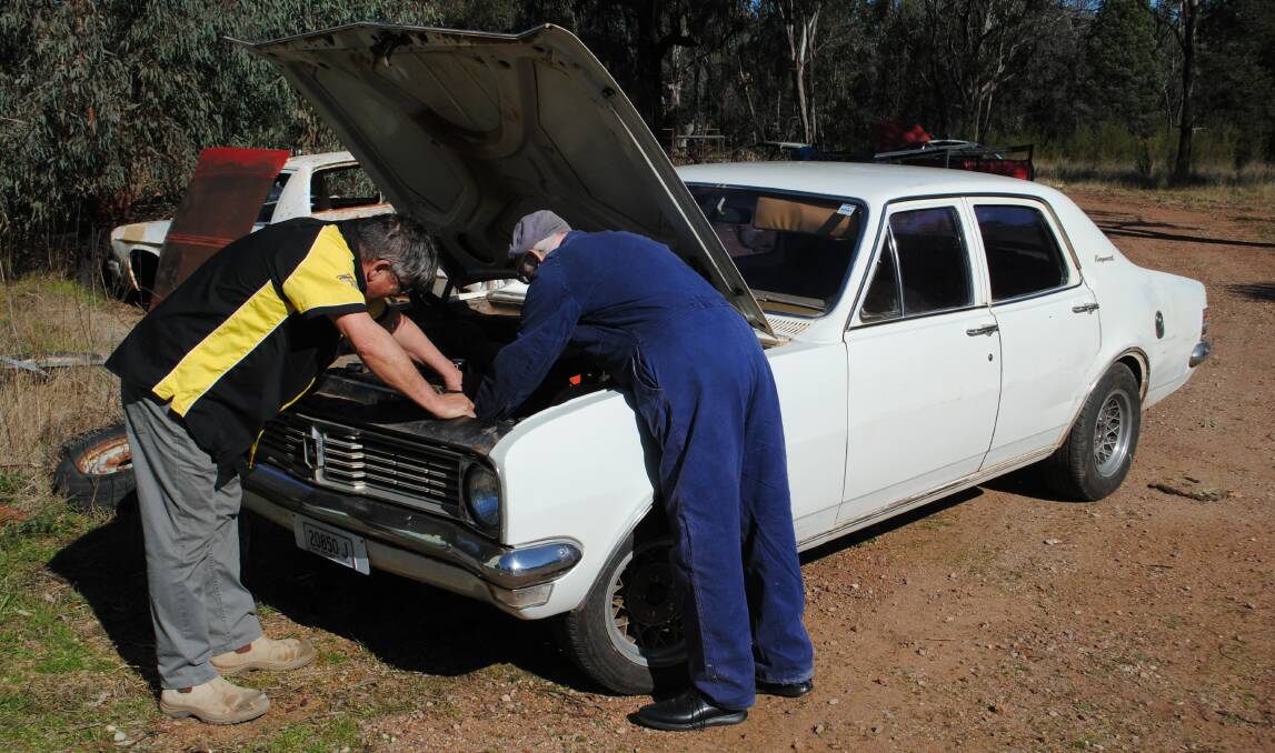IN HIS BLOOD: 95-year-old Norm Finch just couldn't help himself when he met up with John Hutty, checking under the hood of his 1970 HT Holden. Photo: JEFF MCCLURG