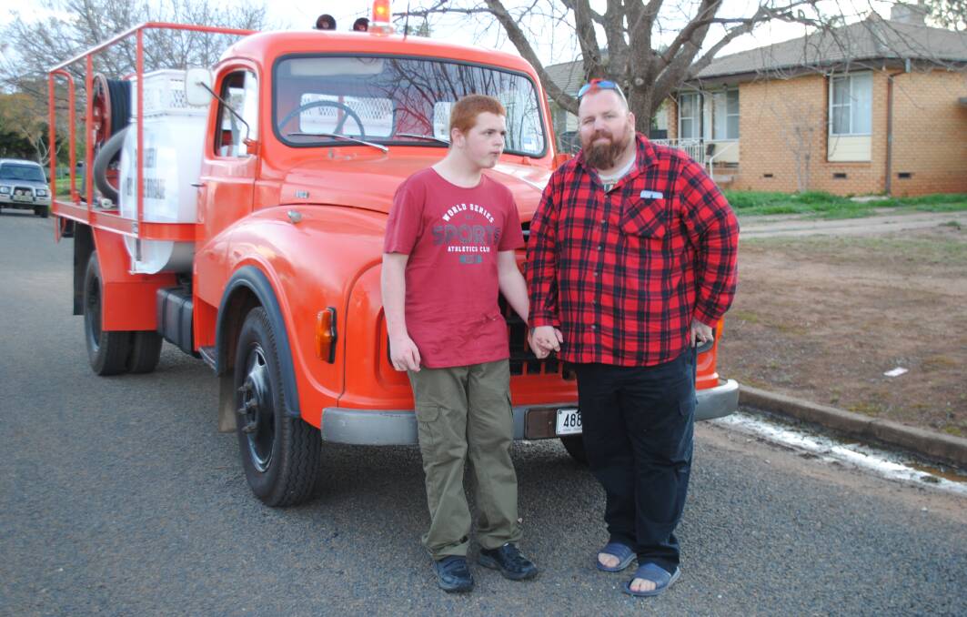 CLOSER LOOK: Creed Caldwell and his dad Broderick with Alan Macdonald's 1971
Leyland fire truck. Photo: Jeff McClurg