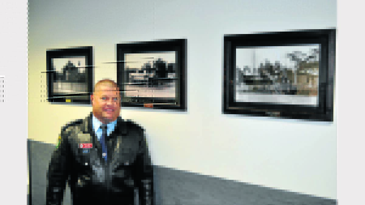 There are many historic photos displayed throughout the new Parkes Police Station such as this one behind Inspector Dave Cooper.